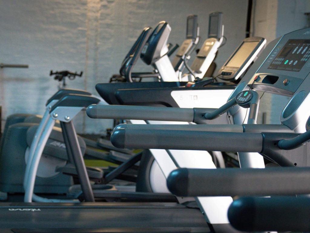 Reihe von Laufbändern und Crosstrainern im Cardiobereich des Studios.