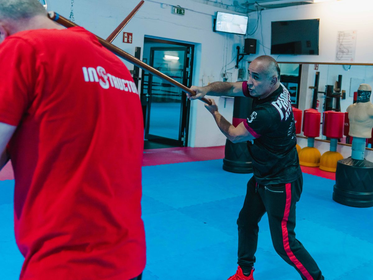 Der Sifu führt im Ausfallschritt einen Stockstoß gegen den Instructor aus.