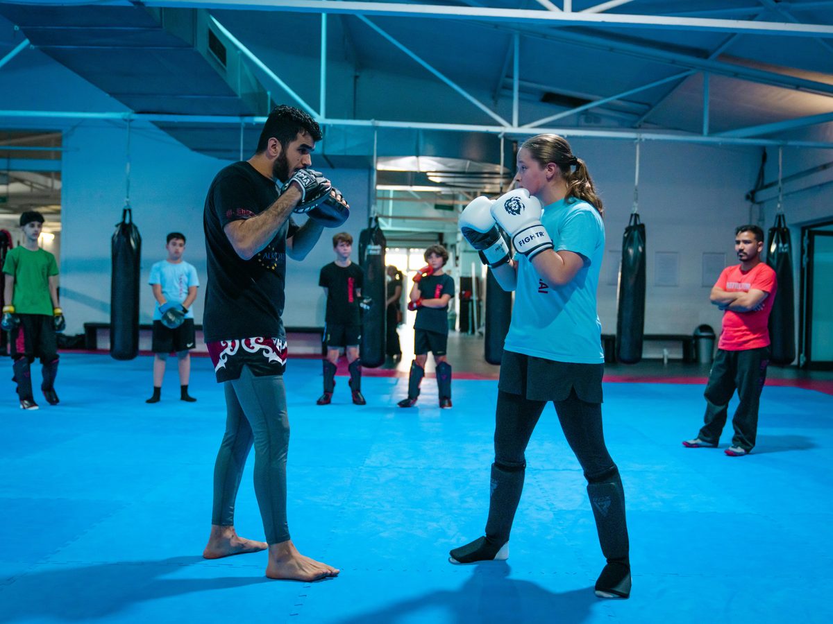 Kickboxen in Aachen 5 Trainer und Trainierende stehen sich in Kampfstellung mit geschlossener Deckung gegenüber.