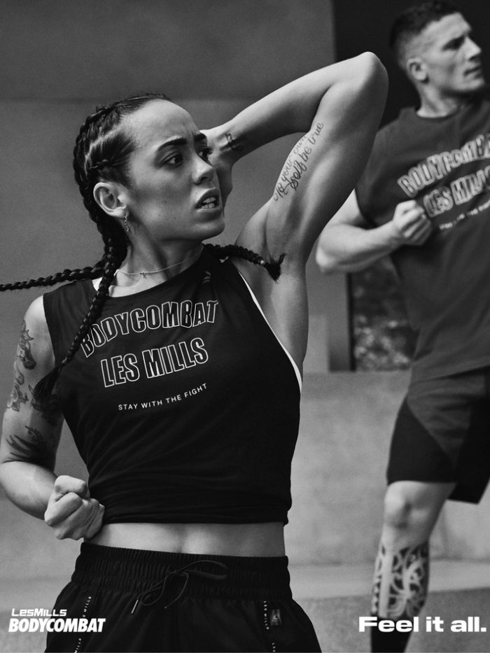 Zwei Teilnehmende im Les-Mills-Bodycombat-Shirt führen eine Schlagbewegung aus.