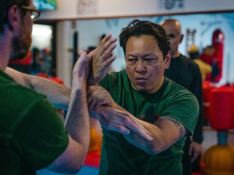 Chi Sao, die klebenden Hände des Wing Chun, zwischen zwei Trainierenden in grünen Shirts.
