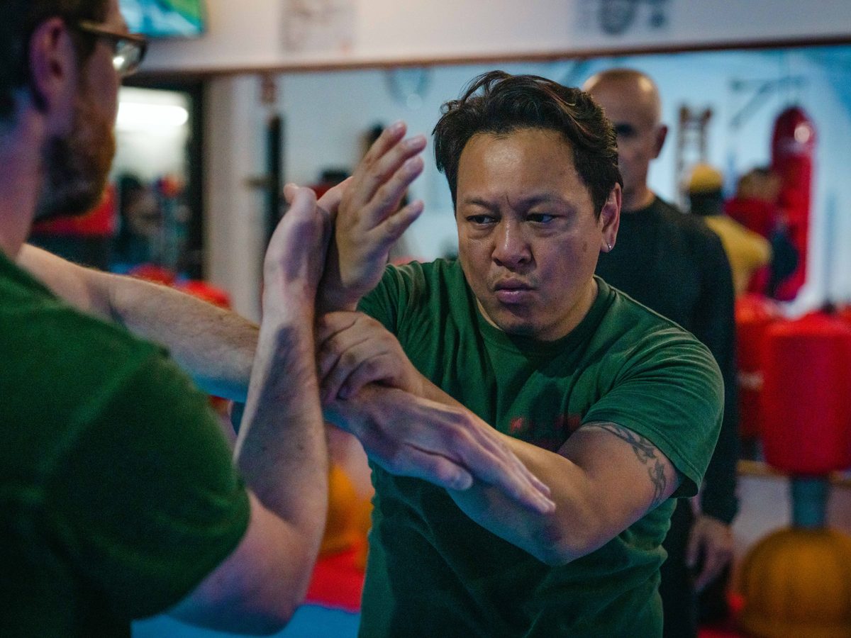 Chi Sao, die klebenden Hände des Wing Chun, zwischen zwei Trainierenden in grünen Shirts.