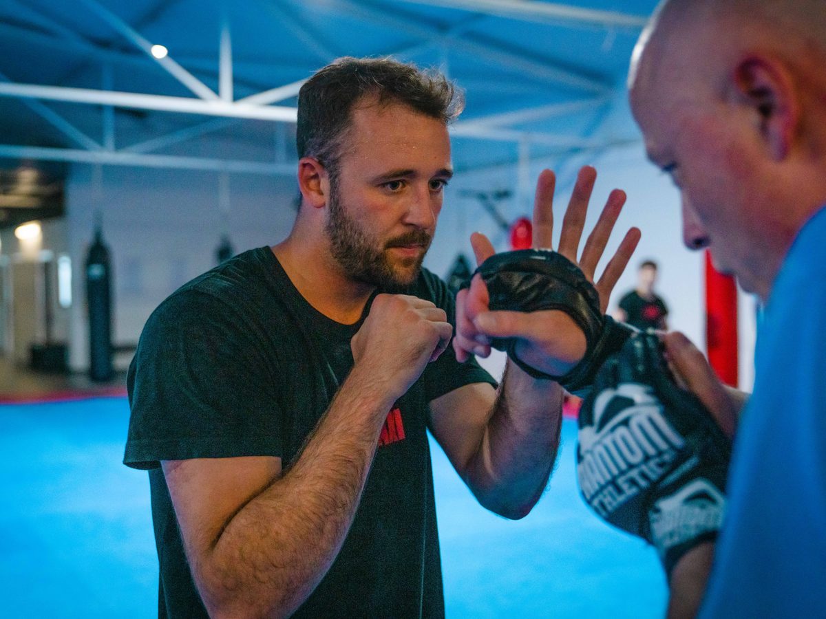 Trainer erklärt einem Schüler in Nahaufnahme eine Handtechnik des Wing Chun.