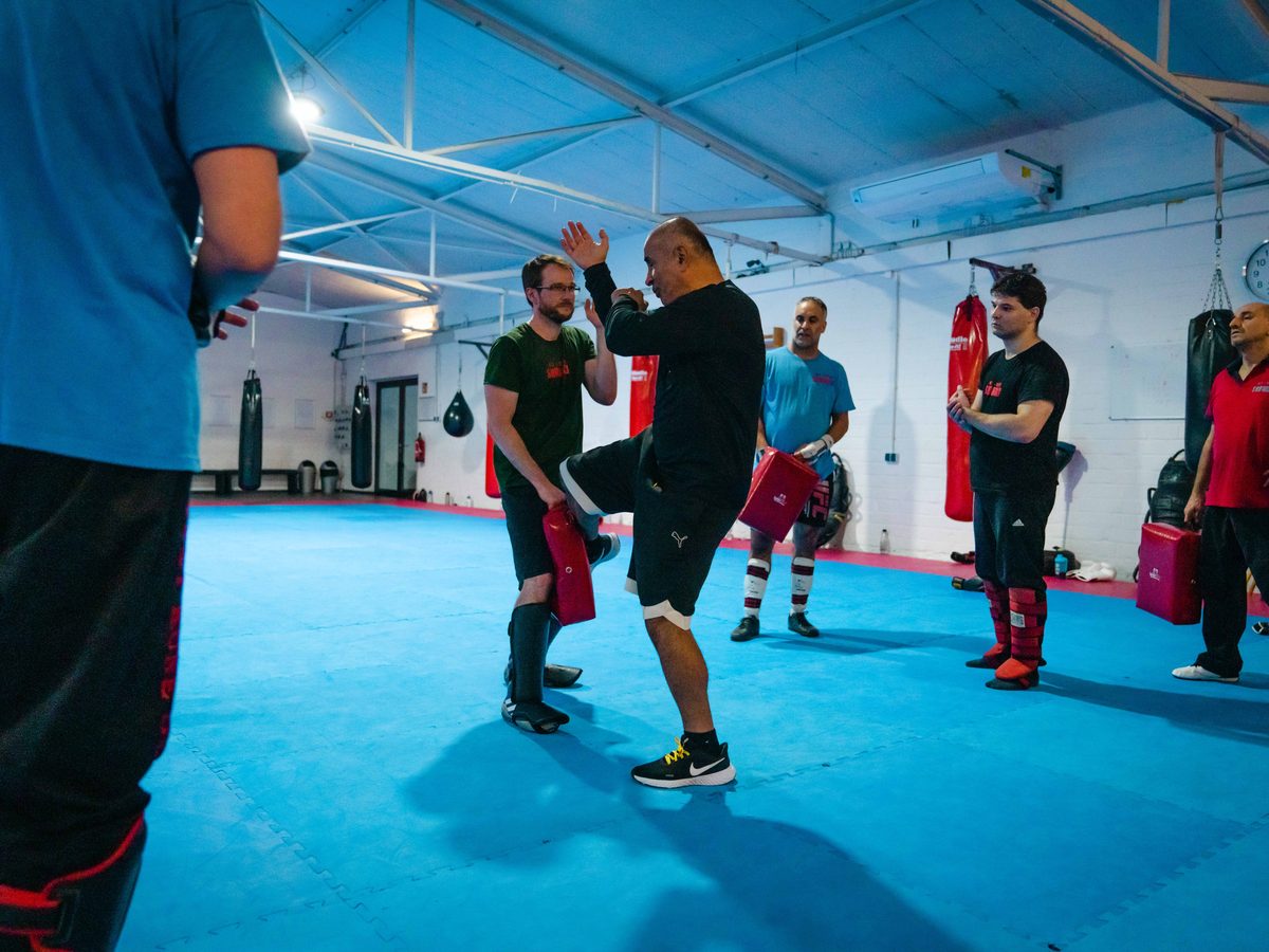 Die Gruppe steht im Kreis und verfolgt eine Technikvorführung in der Trainingshalle.