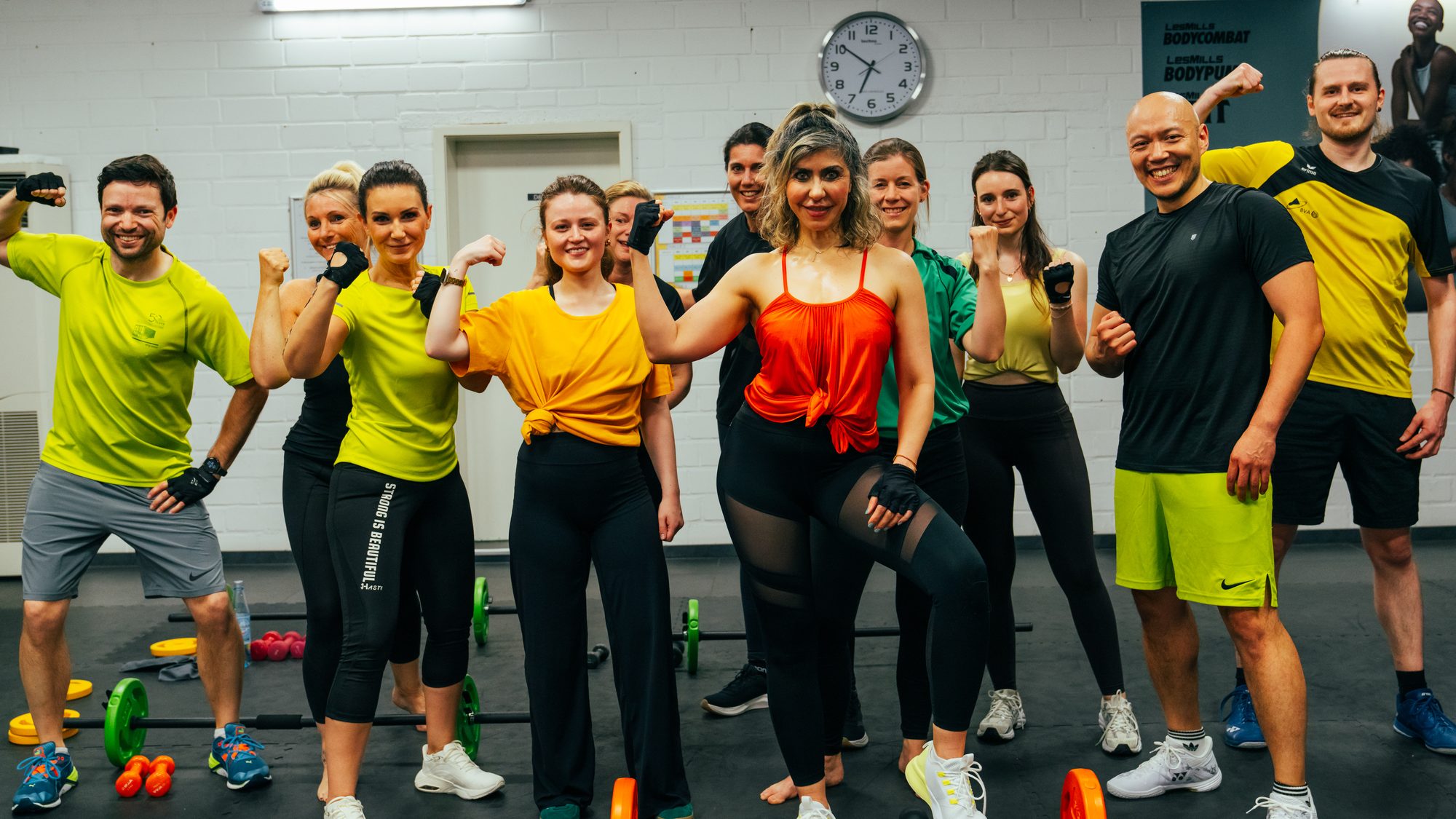 Kursgruppe mit Kurzhanteln und Hantelscheiben nach dem BODYPUMP-Training.