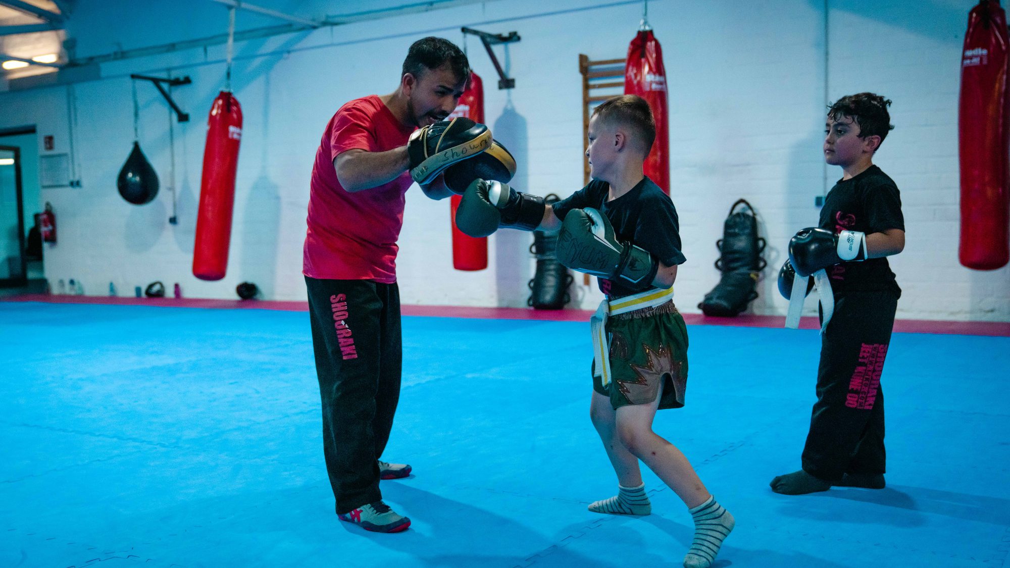 Kindertraining Aachen: Trainer hält die Pratze für ein Kind beim Frontkick.