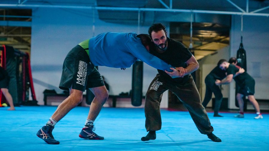 Kickboxen in Aachen 16 Zwei Trainierende ringen im Clinch um die bessere Position auf der blauen Matte.