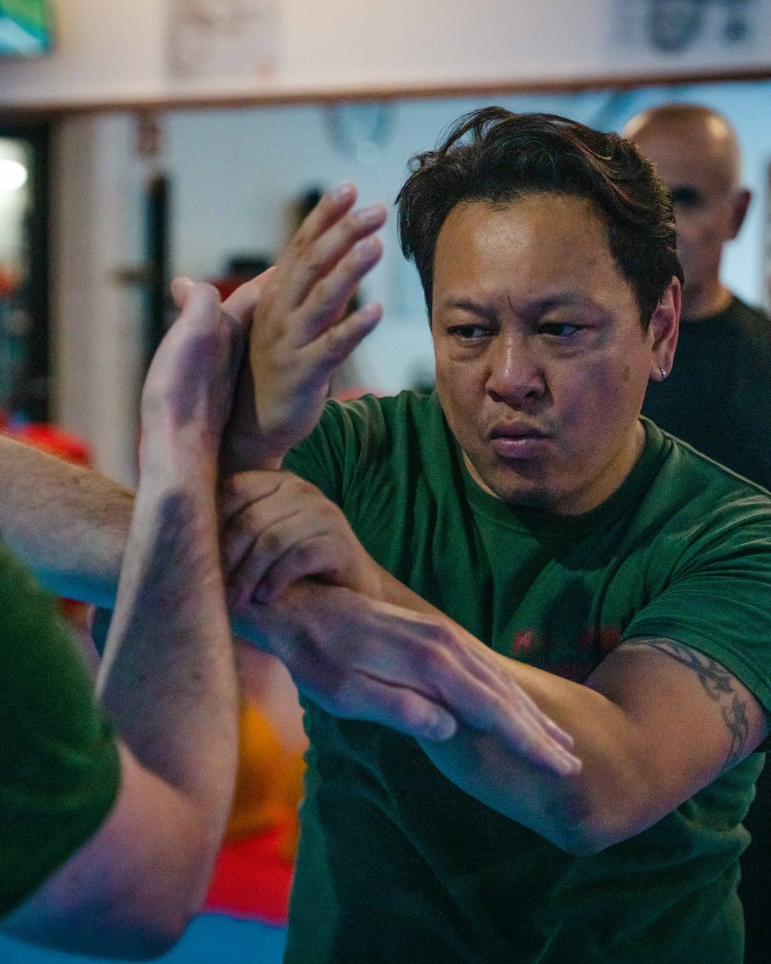 Zwei Trainierende üben Chi Sao, die klebenden Hände des Wing Chun, im konzentrierten Armkontakt.